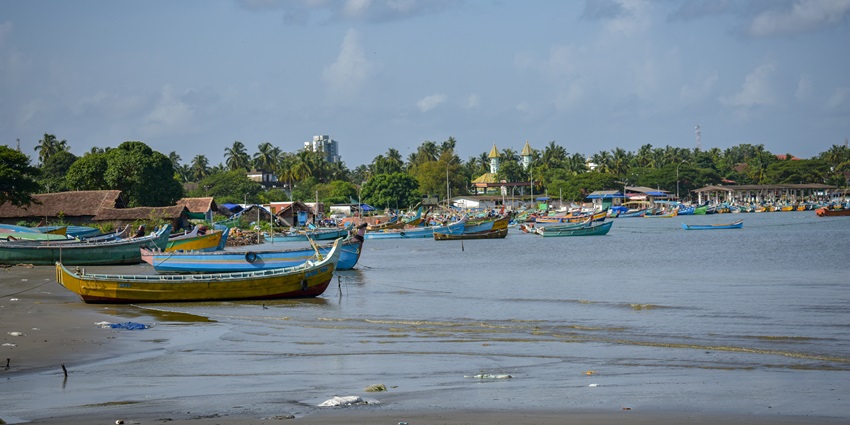 A picture of a waterbody located near the St. Angelo Fort having multiple boats parked around the shore