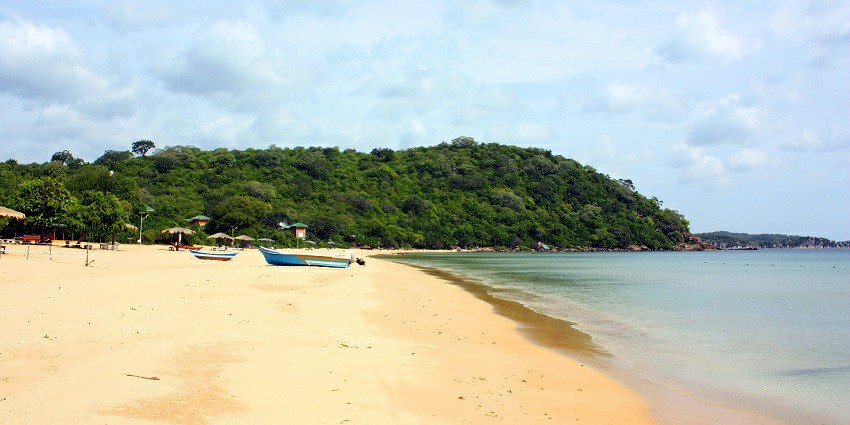 Image of stunning view of a marble beach with smooth white stones, clear blue water.