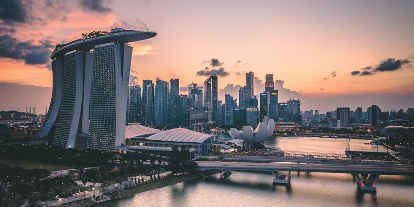 A stunning evening view of the Marina Bay Sands SkyPark with a body of water in front.