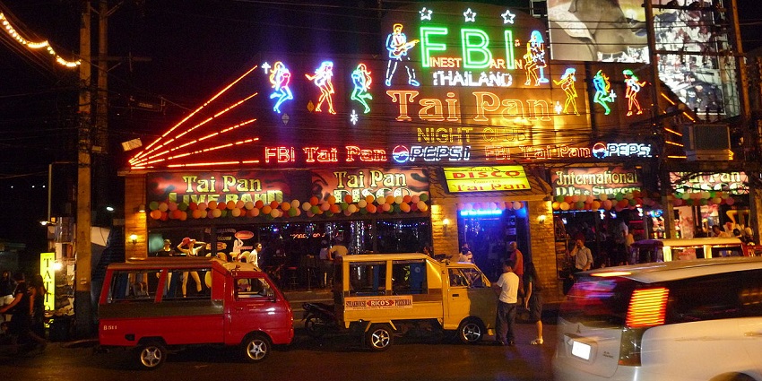 An amazing view of market at night with cars and small trucks moving on the road.