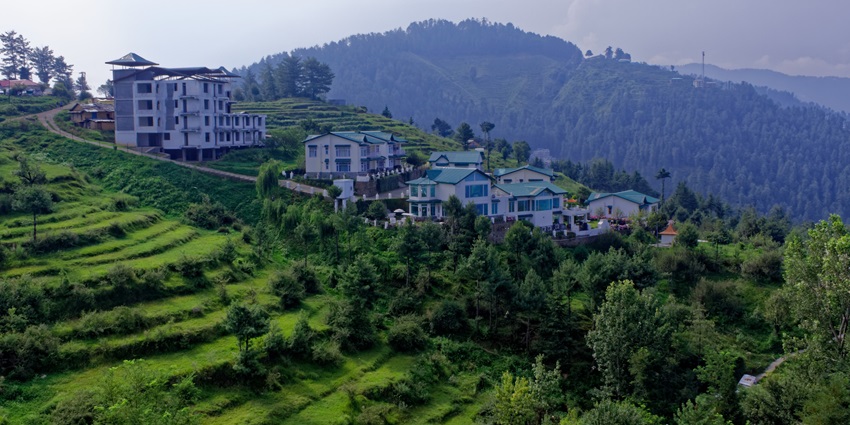A glimpse of Mashobra featuring terraced farming, majestic peaks, and lush greenery.