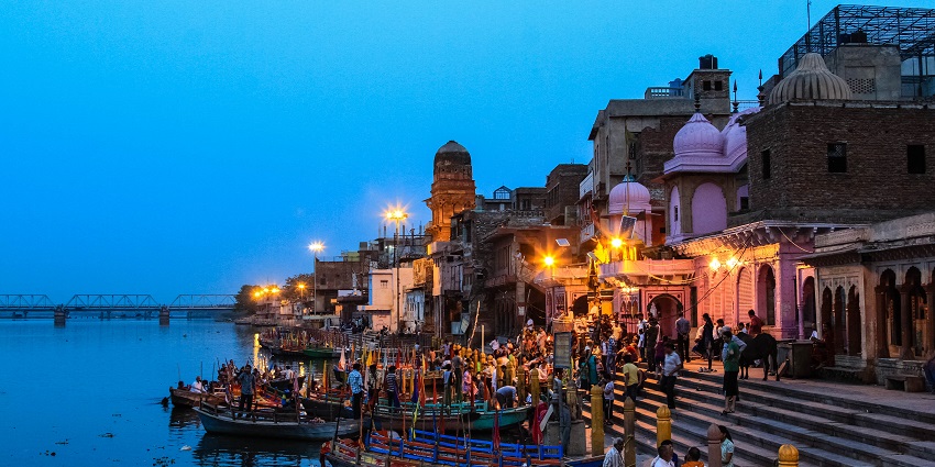 A picture taken at the stroke of night showing people worshipping at a river ghat