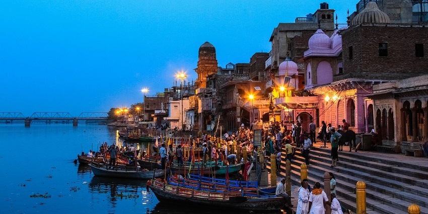 A picture taken at the stroke of night showing people worshipping at a river ghat