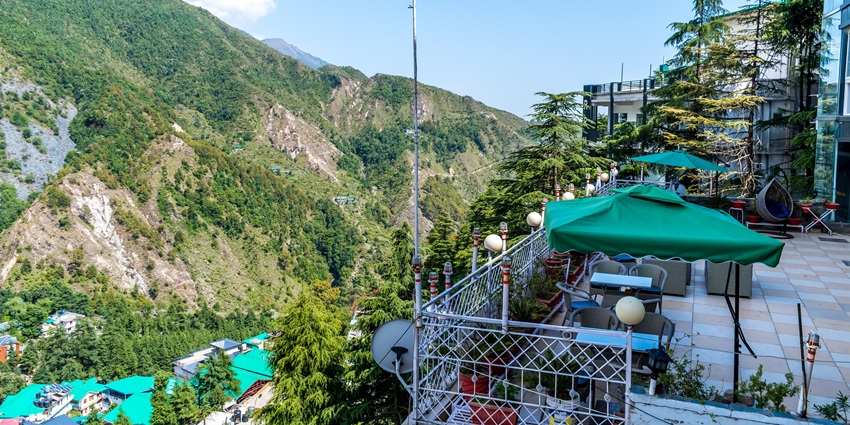 Picturesque view of McLeod Ganj rooftops with mountains - Hill Stations Near Palampur.