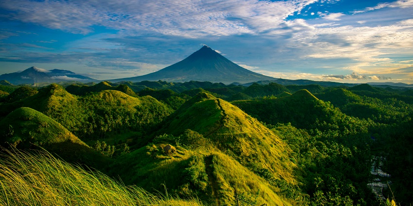 The scenic snapshot of the beautiful hills and the meadows covered in the green grass