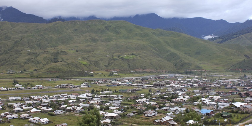 Mechuka village nestled in a picturesque valley, surrounded by lush green mountains.