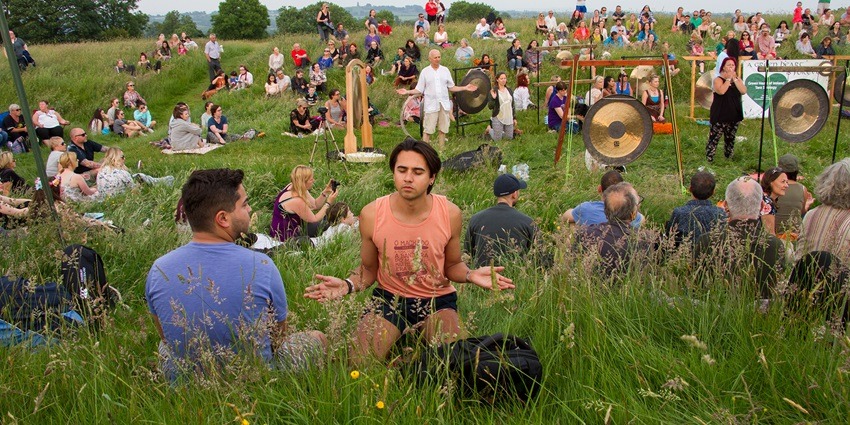 People meditating on a hill