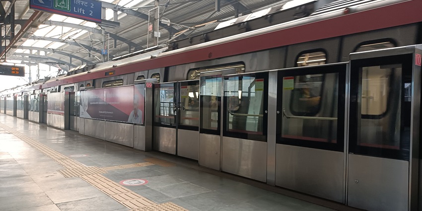 Snapshot of the pink colored Delhi metro arriving on the platform on time