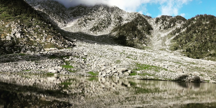 A picture of a majestic mountain with its reflection visible in a lake in front of it