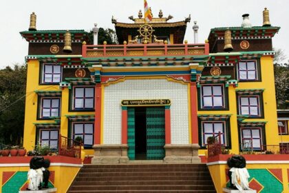 An amazing view of a yellow monastery with a white gate and a brown roof during the day.