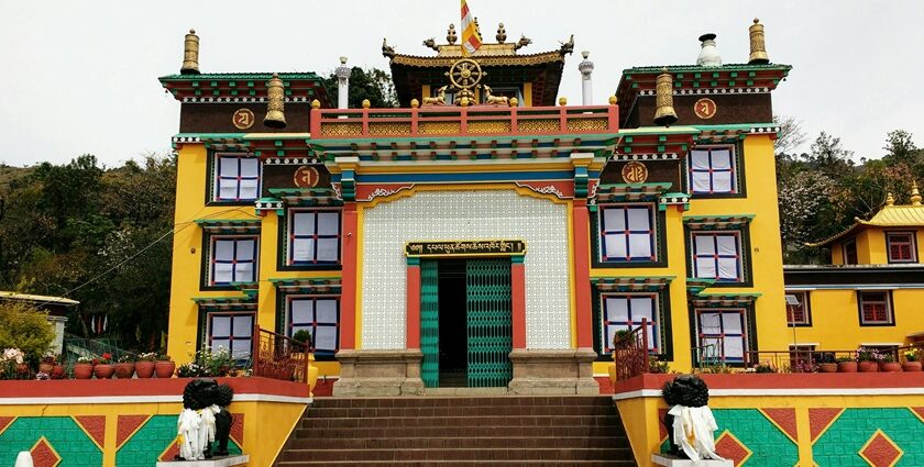 An amazing view of a yellow monastery with a white gate and a brown roof during the day.