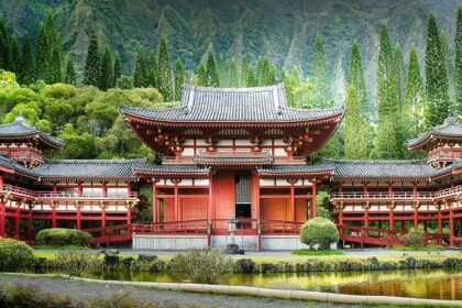 A scenic view of a religious house in hues of red and brown surrounded by lush greenery.