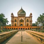 A breathtaking view of a historical monument with long lush green trees on all sides.