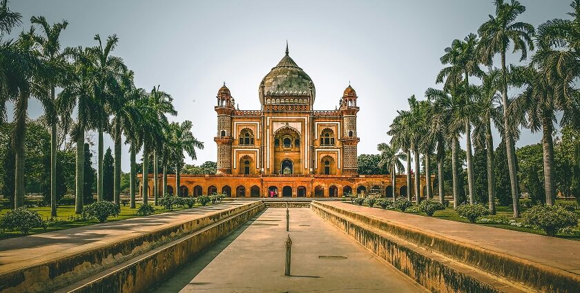 A breathtaking view of a historical monument with long lush green trees on all sides.