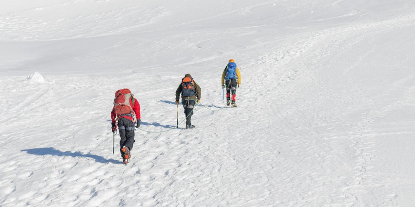 Mountaineers climbing snow-capped mountains