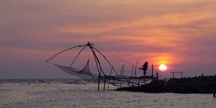 The view of a Chinese net and mesmerising sunset at Munambam Beach, Kerala, India.