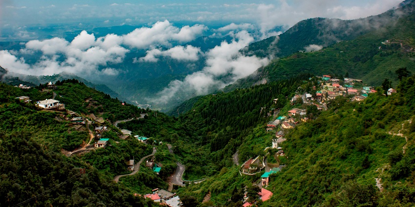 Picturesque view of the city roads trailing through lush forests with hills in background