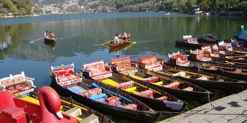 A picture taken from a the corner of the Nainital Lake with boats parked and pleasant weather