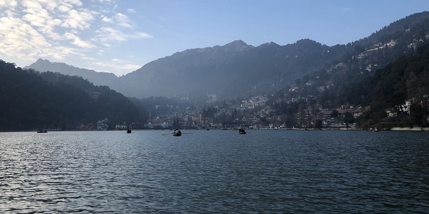 A lake in Nainital with mountains in the background, one of the best places to visit near Delhi in April