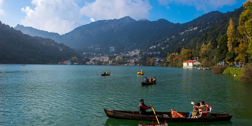 An enchanting view of Nainital featuring shimmering blue waters and colourful boats.