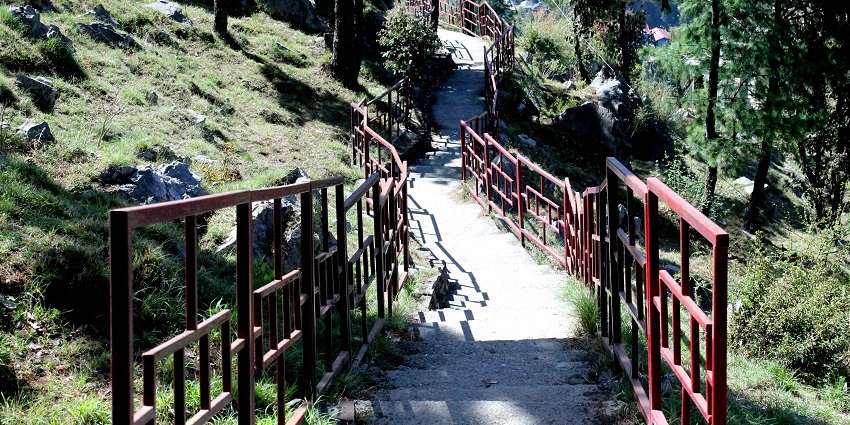 A breathtaking view of a path leading up to a hilltop surrounded by lush greenery.
