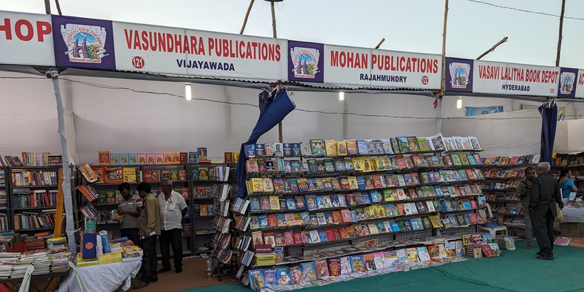 Rows of vibrant book stalls at the Hyderabad National Book Fair 2024, showcasing colorful book displays.