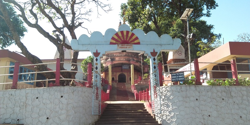 Navagraha Temple entry gate with traditional architecture and a pathway lined.
