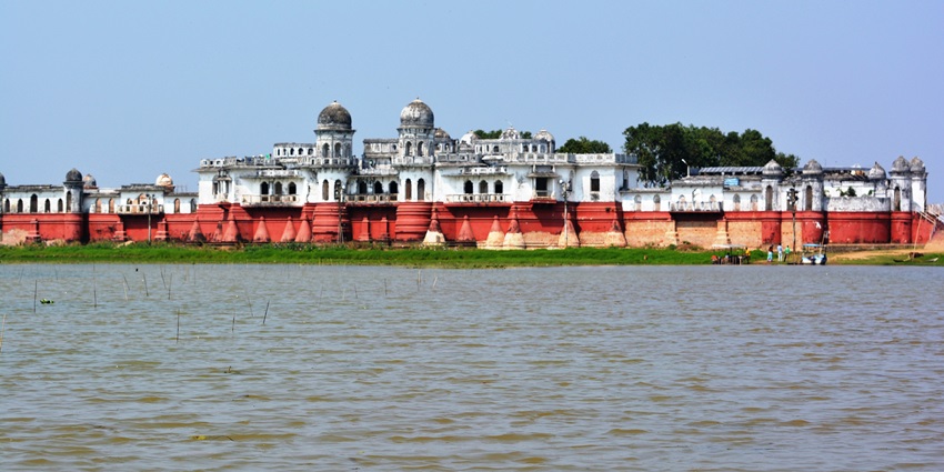 Neermahal palace with white domes and red base majestically rising from serene lake