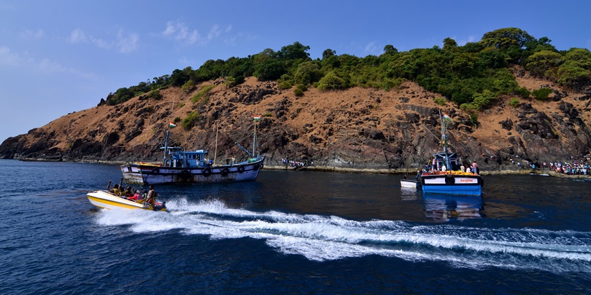 A picture of a lush green island as seen from tourist boats in the Arabian Sea