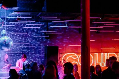 A view of radiant lights and people dancing to the beats in a bar to enjoy after hours.