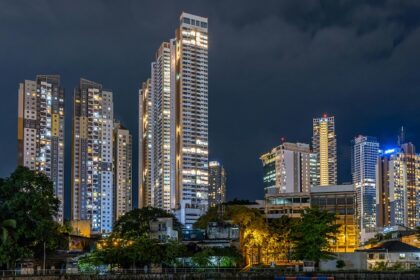 A scenic view of towering buildings with a backdrop of starry sky in the region.