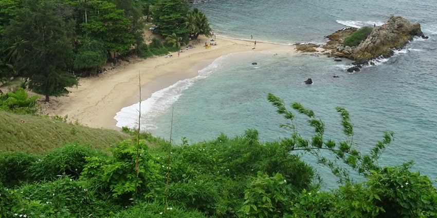 An aerial view of Nui Beach in Thailand surrounded by lush greenery and azure waters.