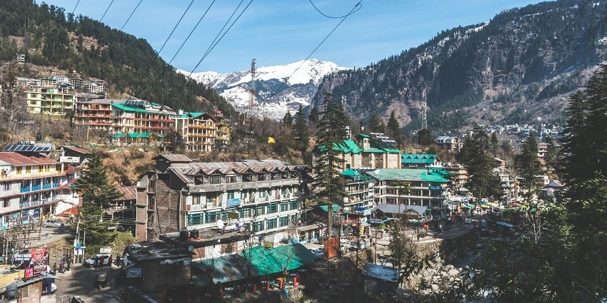 A breathtaking aerial view of a lot of houses in Old Manali surrounded by lush greenery.