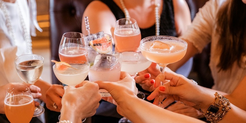 Image of a group of girls enjoying their drinks and doing cheers in a bar/restaurant