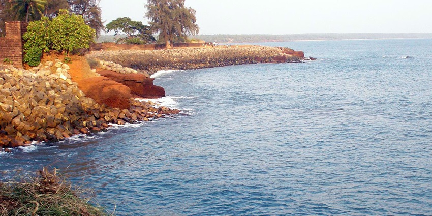 A picture of a beach in Kerala around the Arabian Sea with trees and greenery