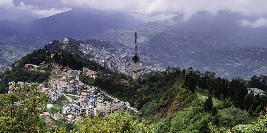 An aerial view of a hill station with houses and greenery