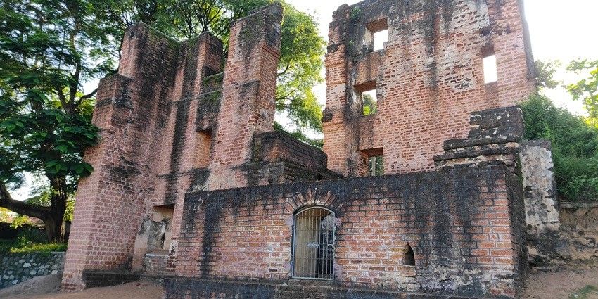 A sideways picture of the St. Thomas Fort in Kollam, surrounded by trees and greenery