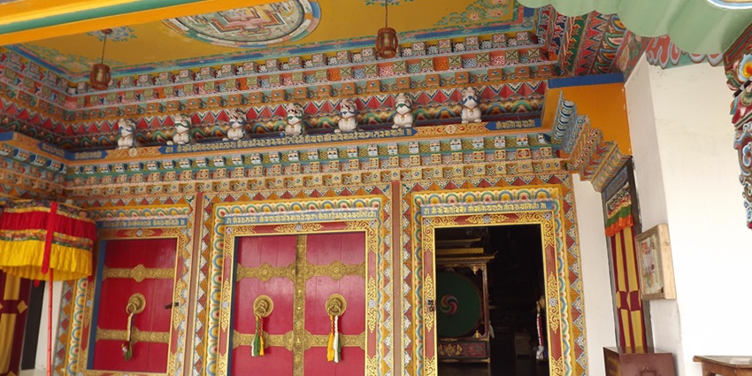 A view of a Monastery in Sikkim with red and yellow walls and gates during the daytime.
