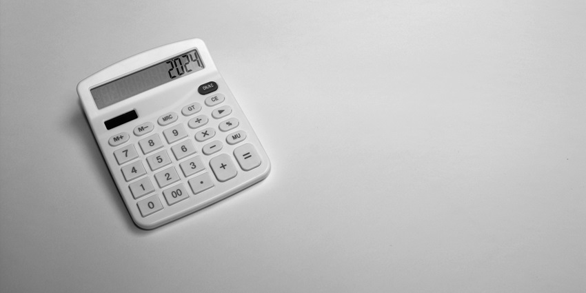 An aerial view of a white calculator with some numbers on it on a white plain surface.