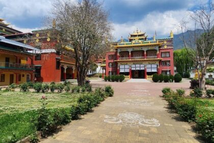 A stunning outer view of the monastery in Bir, Himachal Pradesh, that has a lush green garden.