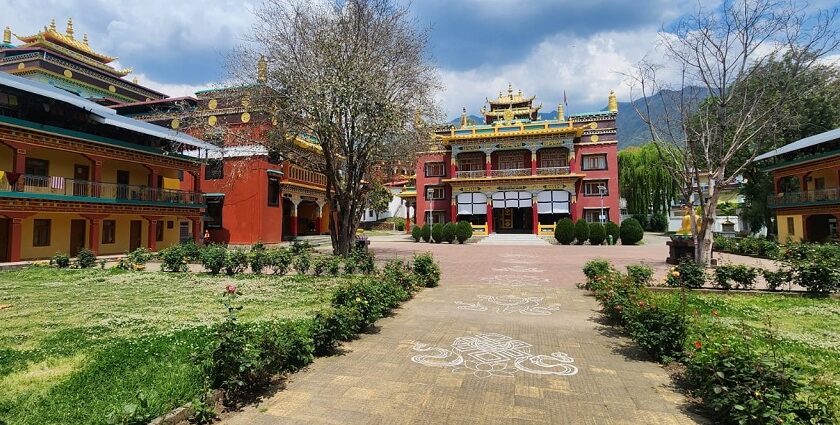 A stunning outer view of the monastery in Bir, Himachal Pradesh, that has a lush green garden.