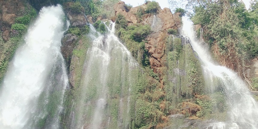 A picture of a waterfall in Karbi Anglong with water cascading down the hill