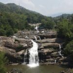 The stunning view of Palchuram Waterfalls, Kerala cascading down amidst lush greenery.