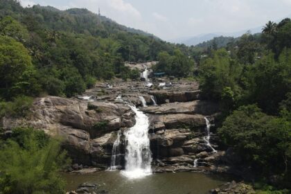 The stunning view of Palchuram Waterfalls, Kerala cascading down amidst lush greenery.