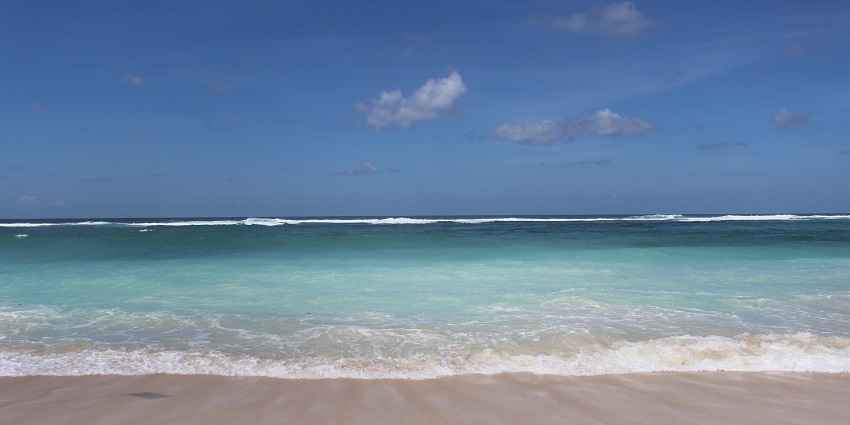 A fascinating view of a turquoise body of water under a cloudy sky during the day.
