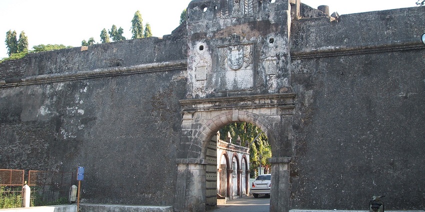 View of the entrance of an old fort with amazing architecture and trees in the background.