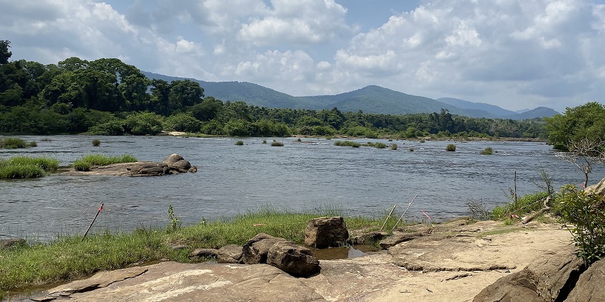 A view of shimmering blue waters surrounded by lush green vegetation in Paniyeli Poru.