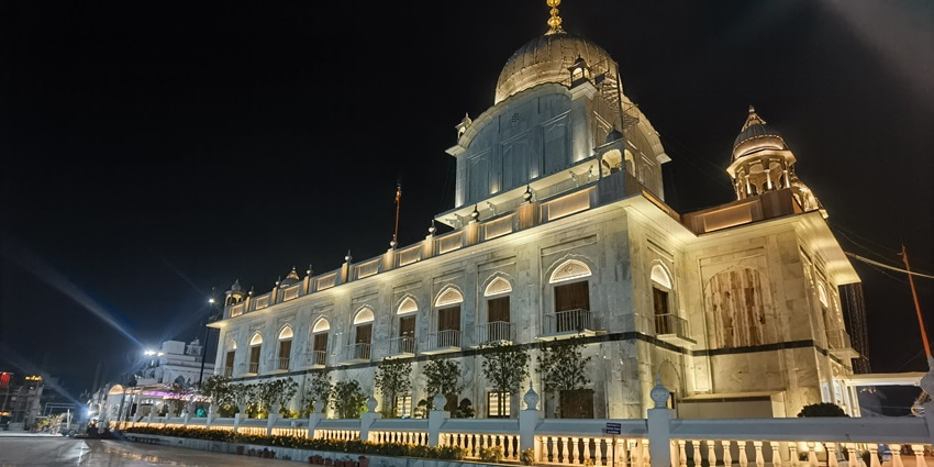 A picture of the beautiful Gurudwara Paonta Sahib with a lit-up compound during nighttime