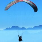 An image of a person enjoying the exciting sports activity above clouds in the daytime.