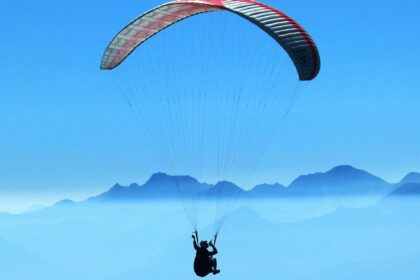 An image of a person enjoying the exciting sports activity above clouds in the daytime.